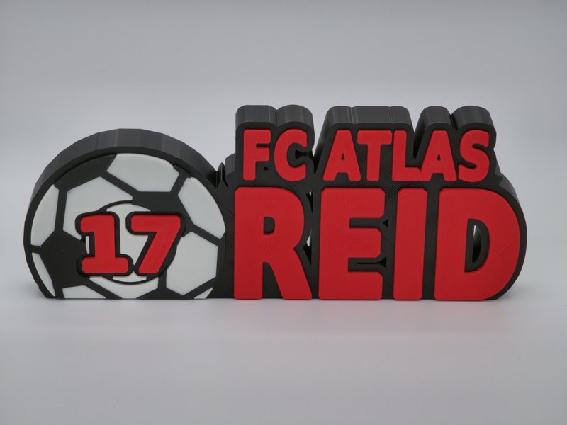 3D-printed freestanding sports sign reading FC ATLAS REID with jersey number 17 beside a black-and-white soccer ball, Lava Red lettering on a Charcoal Black base