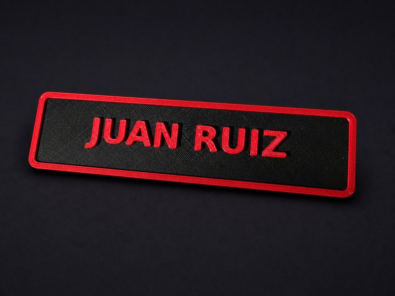 3D-printed toolbox name plate reading JUAN RUIZ in red on black