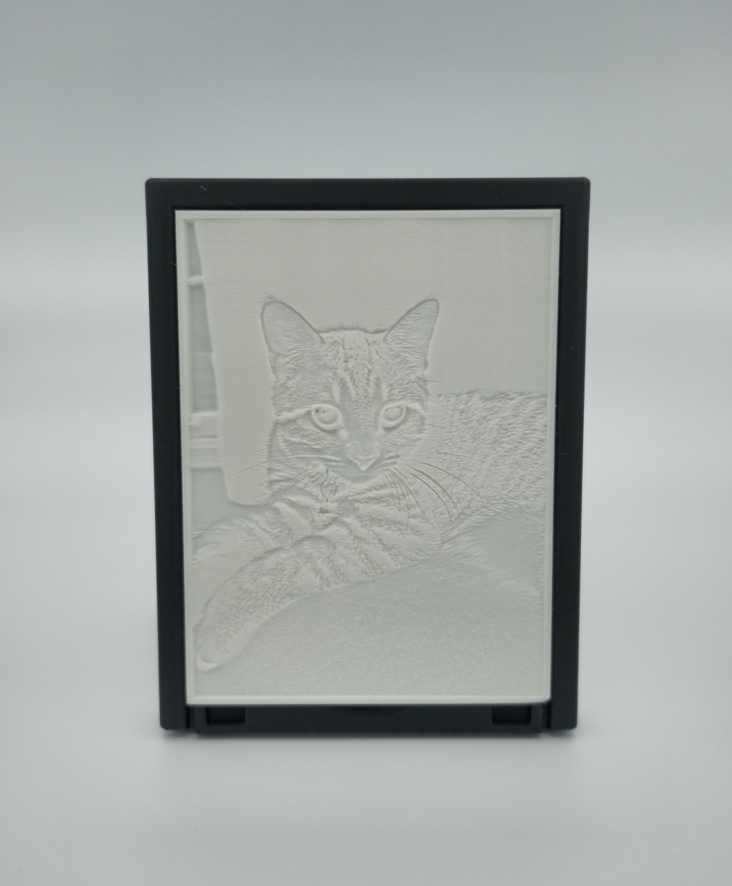 Close-up of an unlit photo lithophane showing the fine printed relief that forms the image